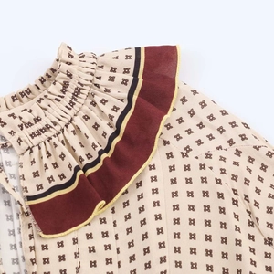 Close-up of bohemian floral dress neckline with ruffled edges and fine geometric patterns