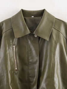 Detailed view of an olive green faux leather jacket with metal snap buttons and zipper