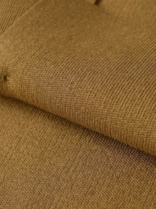Macro detail of the high-quality fine rib knit texture and soft ochre fabric finish