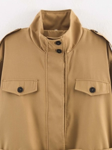Detail der khakifarbenen Jacke mit geknöpften Pattentaschen und Schulterklappen