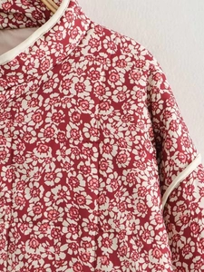 Detail of floral quilted jacket featuring stand collar and contrast piping texture