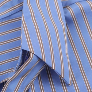 Macro shot of light blue cotton fabric with dark brown and white stripes detail on shirt