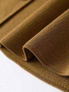 Macro view showing detailed vertical ribbed texture of camel knit sweater fabric