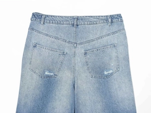 Detailed view of the back pockets and distressed ripped details on high-waist denim jeans