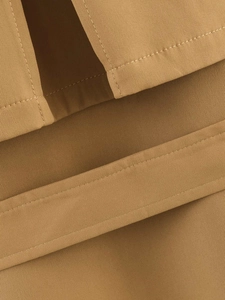 Makroaufnahme von khakifarbenem Trenchcoat mit Twill-Stoffstruktur und feinen Nähten