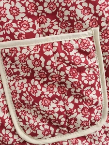 Detailed macro view of quilted floral jacket featuring red pattern and patch pocket design