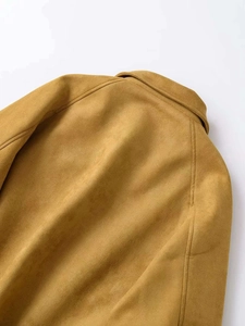 Détails des coutures de l'épaule et du col d'une veste en daim jaune moutarde