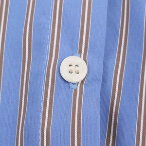 Detailed macro view of striped shirt fabric texture with a white four-hole button closure