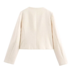 Detail view of the back of a beige cropped tweed jacket with textured woven fabric