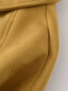 Détail macro du daim jaune moutarde montrant les coutures et la texture du tissu