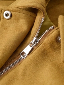 Détail du zip métallique et du bouton pression argenté sur la veste en daim moutarde