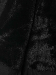 Gros plan sur la texture en fourrure synthétique noire d'une veste de ski coupe-vent