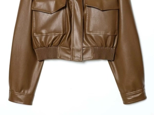 Detail view of brown cropped faux leather utility jacket with flap pockets and elastic hem