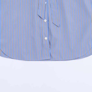 Detail of blue and brown striped shirt showing white button and hanging waist tie cord