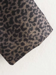 Close-up of vintage leopard print fabric texture on a long coat with soft fuzzy finish