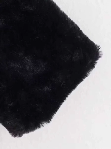 Close-up of premium black faux fur texture on retro loose winter coat with high collar