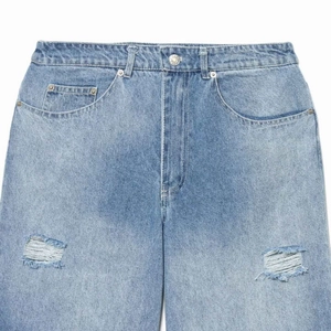 High-waisted ripped wide-leg denim jeans in light blue wash with distressed details