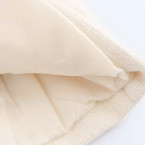 Close-up of premium cream tweed fabric texture and silky lining on a short jacket