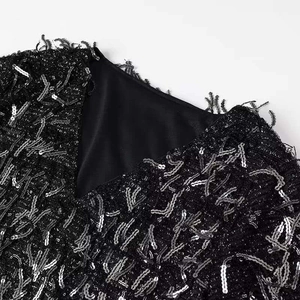 Sleeveless black sequin dress with elegant V-neckline and shimmering fringe detail texture