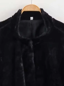 Detail shot of the stand-up collar and thick black faux fur texture on this winter jacket