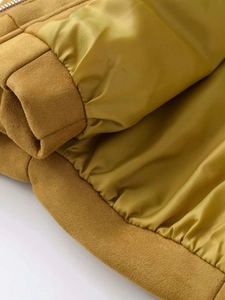 Détail d'une veste en daim jaune moutarde montrant le poignet élastique et la doublure