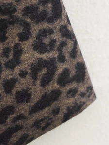 Close-up detail of the heavy leopard print fabric texture on this vintage long coat
