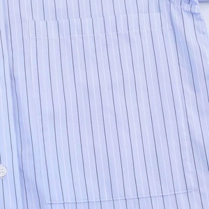 Detail of light blue striped shirt featuring breast pocket and white button stitching