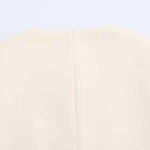 Macro shot of off-white woven fabric texture and vertical stitching detail on jacket