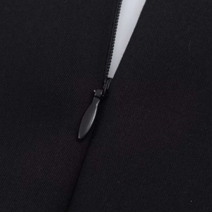 Close-up of black sleeveless romper featuring a hidden back zipper and metal teardrop pull