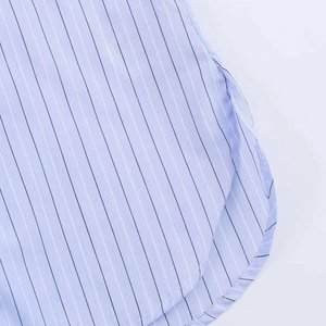 Detail of light blue striped shirt featuring a curved hemline and reinforced side slits