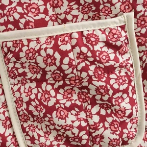 Quilted floral jacket with red patterns, white piping details and front pocket design