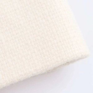 Detailed macro view showing the premium knit texture of the white tweed style jacket