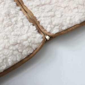 Detail of lamb wool vest with brown suede trim and premium metal zipper closure