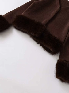 Detail of dark brown knitwear with luxurious faux fur trim on cuffs and hemline