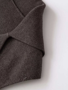 Detailed macro view of heavy-knit fabric texture on dark grey waistcoat vest