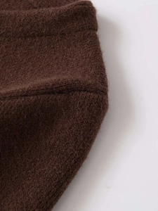 Detail shot of brown knit fabric with faux fur texture and precise stitching detail