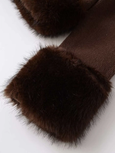 Detailed close-up of dark brown knit gloves with plush faux fur trim on cuffs