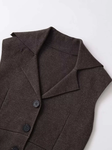 Close-up of dark coffee textured vest with large notched lapel and black buttons