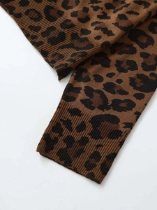 Detailed close-up of leopard print knit sweater featuring ribbed cuffs and soft texture