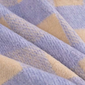 Close-up of soft brushed knit fabric featuring a purple and beige plaid pattern texture