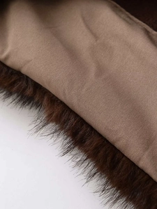 Close-up of the plush faux fur texture and smooth inner lining on a dark brown sweater