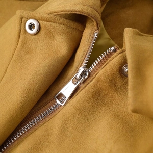 Vue détaillée d'une veste en daim moutarde avec fermeture éclair et boutons en métal argenté