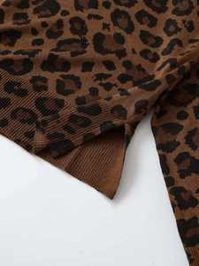 Detailed close-up of leopard print knit sweater featuring ribbed hem and side slit detail