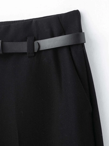 Detail der schwarzen Culotte-Hose mit hohem Bund, Kunstlederguertel und seitlicher Tasche