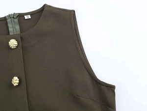Detail of olive green dress featuring gold embossed buttons and a back invisible zipper
