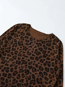 Detailed close-up of ribbed crew neck and textured leopard print knit on autumn sweater