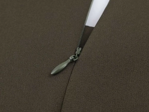 Close-up of invisible zipper and woven fabric texture on olive green midi dress