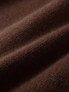 Close-up of brown knit fabric showing thick texture and soft faux fur fiber details
