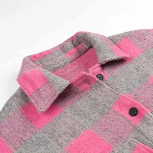 Detailed close-up of pink and grey plaid flannel shirt featuring lapel and black buttons