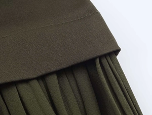 Detailed close-up of dark green midi dress featuring pleats and a matching waist belt